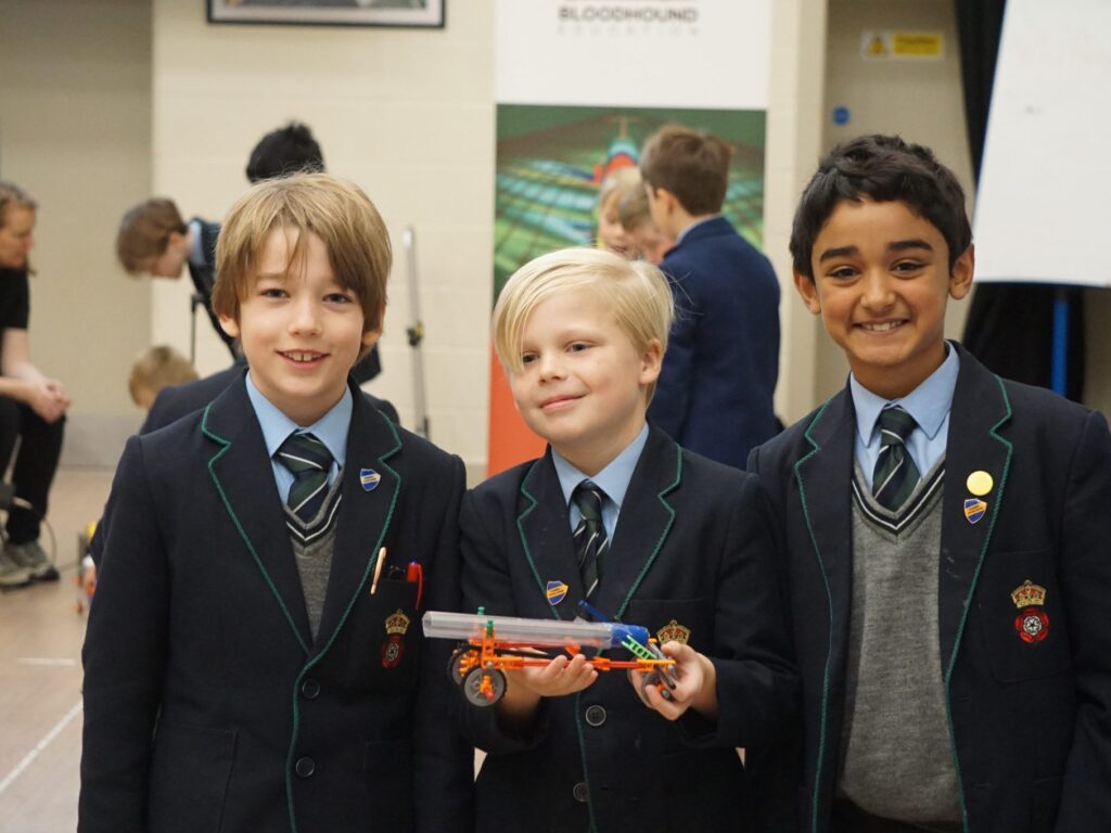 students holding a model car